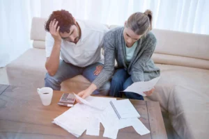 A couple reviewing documents while sitting on a couch.