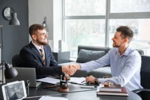 A person shaking hands with a lawyer in an office setting.