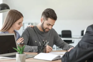 Young couple signing a living will at a lawyer’s office.